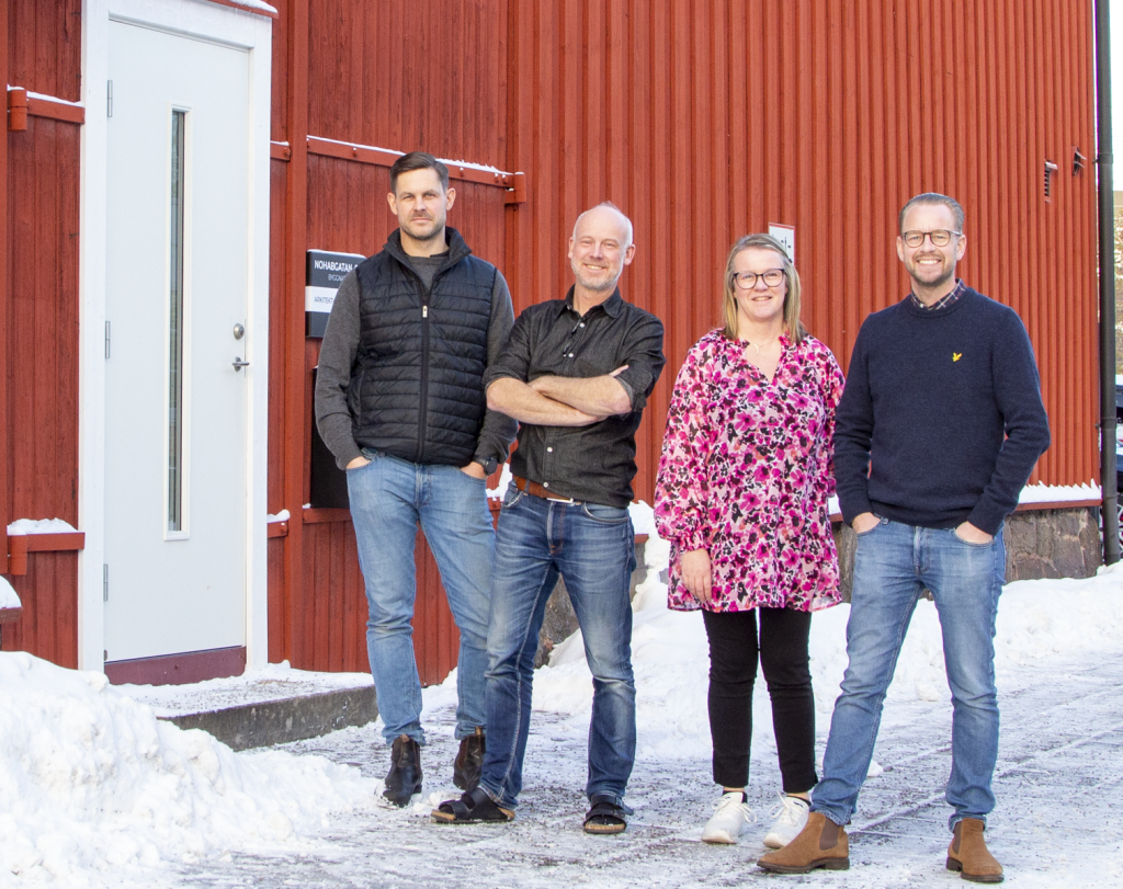 Personalen om fyra står utomhus framför fastigheten. Snö på marken.