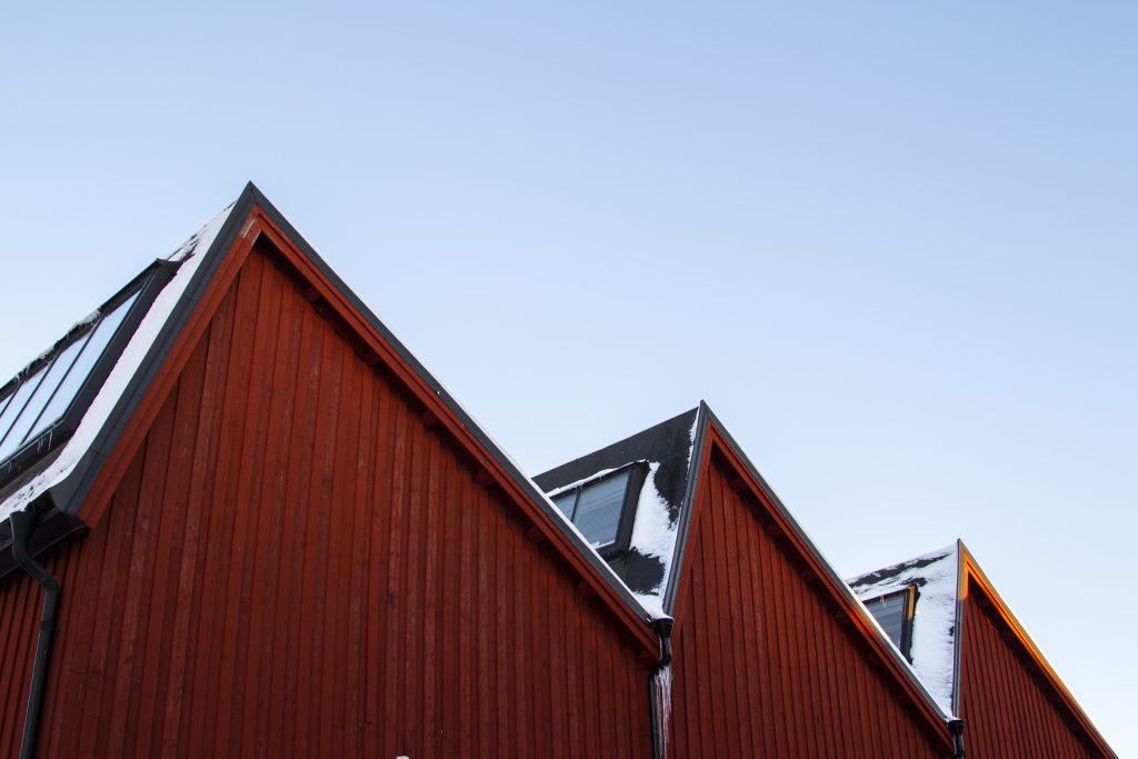 Sågtandat svart tak och röd träpanel